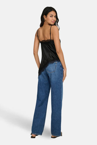 Chemisier noir sans manches de ONLY, avec détails en dentelle, combiné avec un jean bleu et des sandales noires.