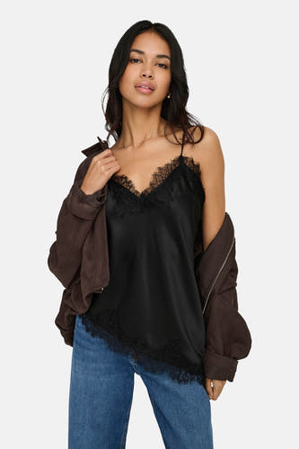 Chemisier noir sans manches de ONLY, avec détails en dentelle, porté avec une veste marron et un jean.