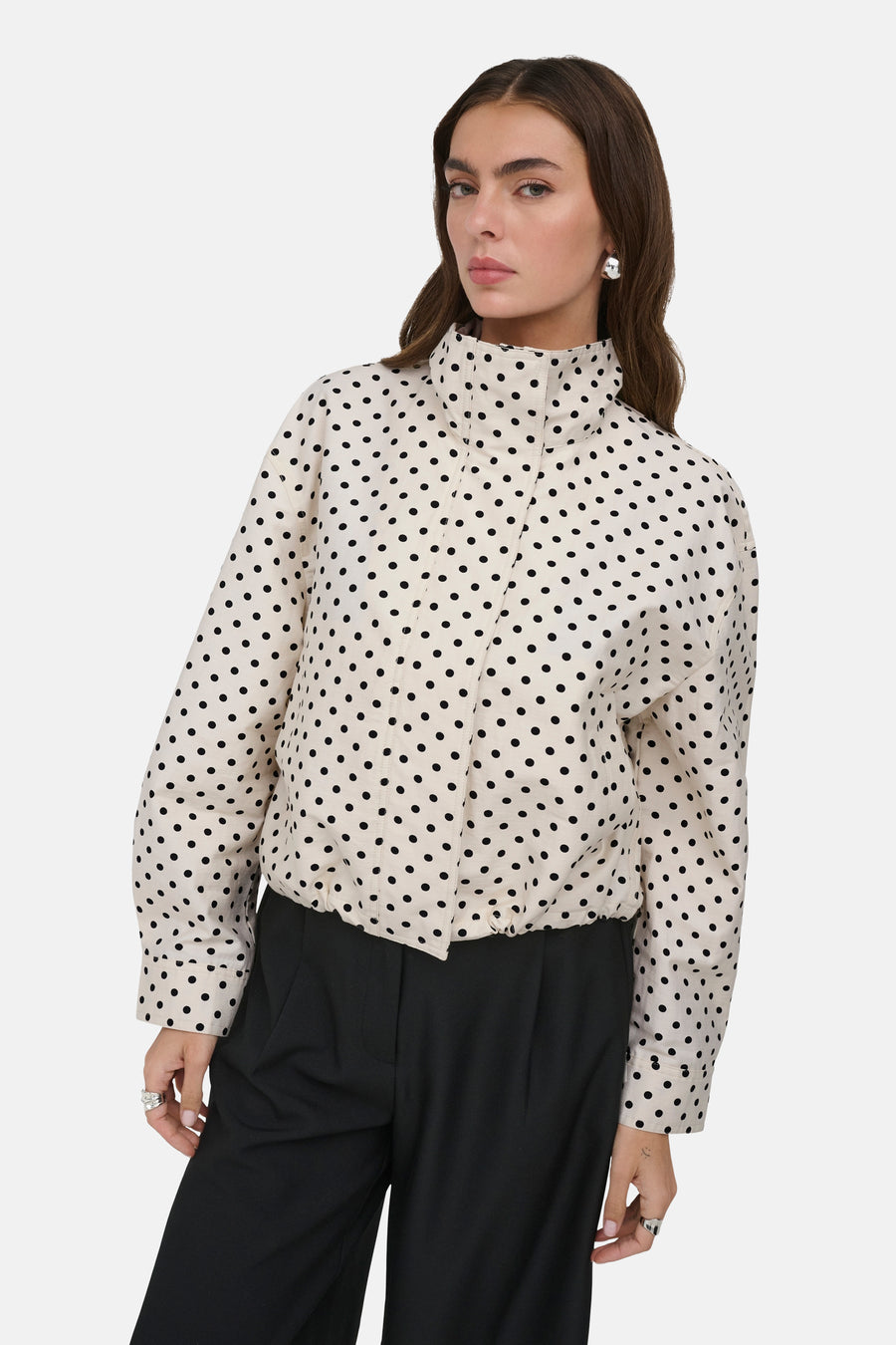 Veste courte blanche ONLY® à pois noirs, col montant et ourlet élastique, portée par un mannequin.
