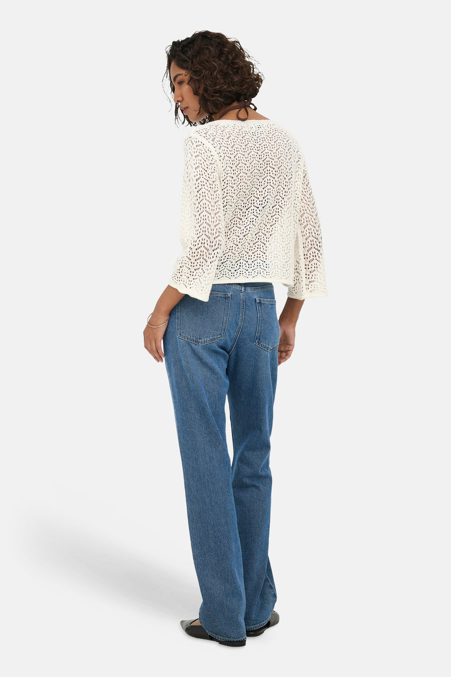 Ecru gebreide trui met openwerkpatroon van JDY, zichtbaar van achteren, gekleed met blauwe jeans en zwarte platte schoenen