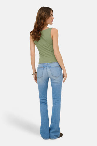 Haut sans manches vert de ONLY®, vu de dos sur un mannequin portant un jean, un bracelet argenté et des chaussures foncées.