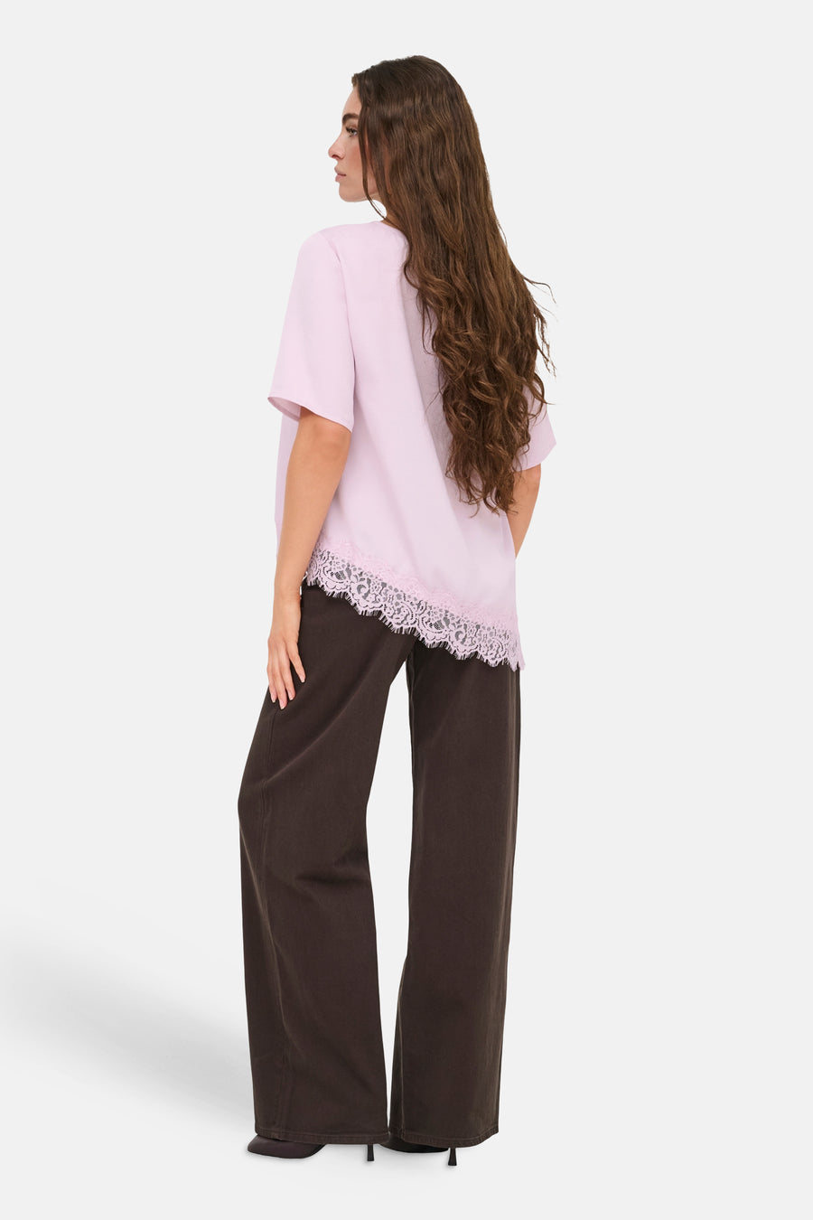 T-shirt rose de JDY à manches courtes et ourlet en dentelle, combiné avec un pantalon marron foncé.