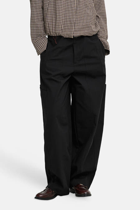 Zwarte cargobroek van JDY, breed model met zijzakken, gedragen met geruit overhemd en bruine loafers, front view