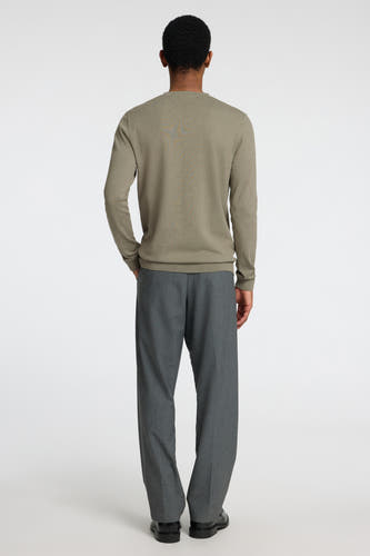 Pull vert à col rond de SELECTED, vu de dos, combiné avec un pantalon gris et des chaussures noires.