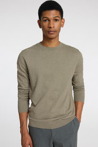 Pull vert avec col rond de SELECTED, porté avec un pantalon gris.
