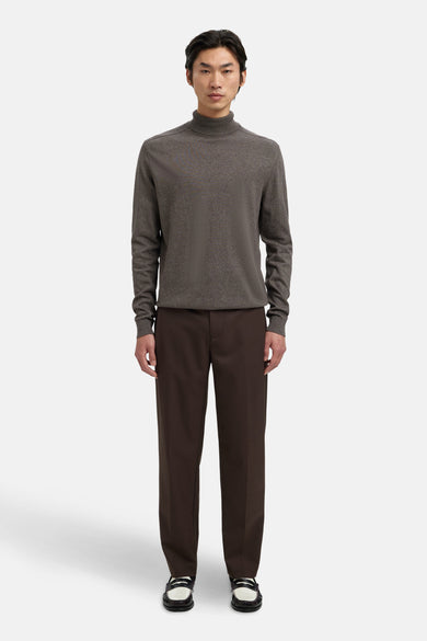 Collier de perles brun de SELECTED, porté avec un pantalon brun foncé et des loafers noir et blanc.