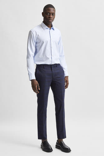 Chemise bleue à manches longues de SELECTED, portée avec un pantalon à carreaux et des loafers noirs.