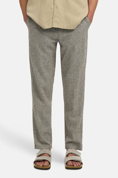 Pantalon marron de SELECTED, avec une texture fine et une coupe décontractée, combiné avec un t-shirt marron et des sandales.