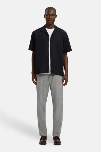 Blauwe broek van SELECTED, met een subtiel patroon en gecombineerd met een wit T-shirt en zwarte blouse.