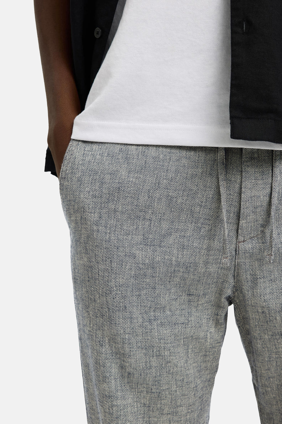 Pantalon bleu de SELECTED, avec un motif chiné et une texture légère, porté avec un t-shirt blanc.