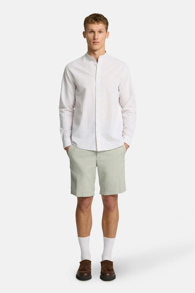 Short vert de SELECTED, combiné avec un chemisier blanc, des chaussettes blanches et des chaussures marrons.