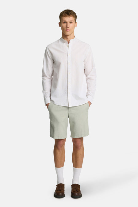 Short vert de SELECTED, combiné avec un chemisier blanc, des chaussettes blanches et des chaussures marrons.