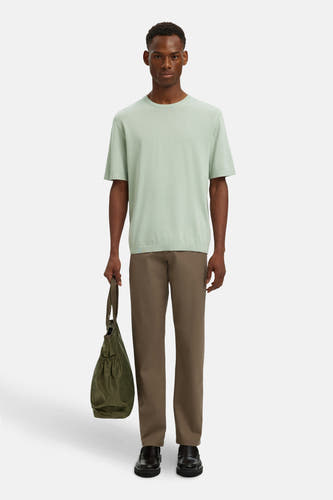 Pantalon de costume brun de SELECTED, porté avec un T-shirt vert clair, une sacque et et des chaussures noires.