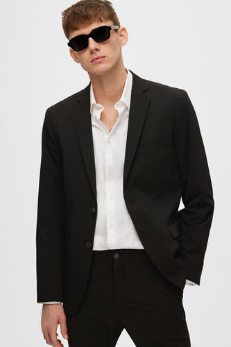Blazer noir de SELECTED, porté avec une chemise blanche et un pantalon noir.