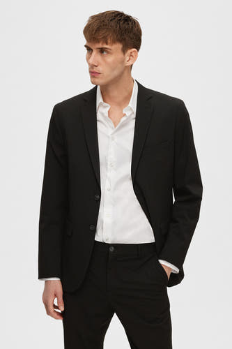 Blazer noir de SELECTED, avec une chemise blanche et un pantalon noir, mannequin avec la main dans la poche.