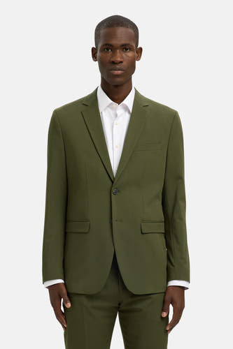 Blazer vert de SELECTED, porté avec un chemise blanc sur sur fond blanc.