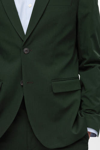 Blazer vert de SELECTED avec une fermeture à boutons et une poche poitrine, combiné avec un chemisier rayé.