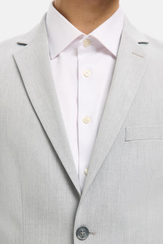Blazer gris de SELECTED, avec un chemise blanc en dessous et une fermeture à un seul bouton.