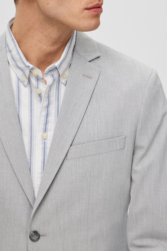 Blazer gris de SELECTED, avec une subtile texture et un chemisier rayé en dessous.