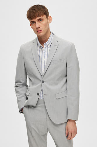 Blazer gris de SELECTED porté sur un chemisier rayé et associé à des chaussures noires.