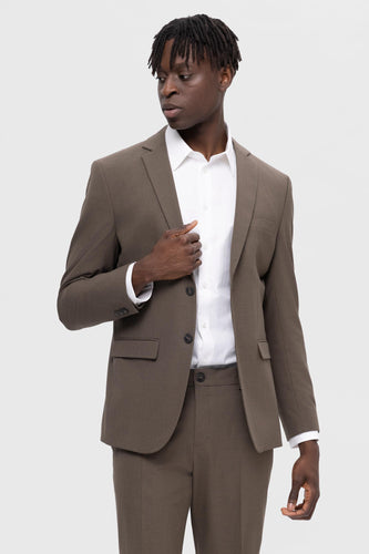 Man in bruin pak met wit overhemd.