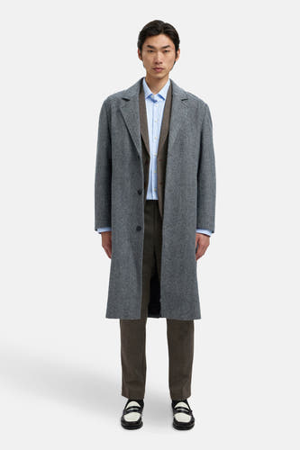 Blazer marron de SELECTED, associé à une chemise bleue et un manteau gris, porté avec des pantalons marrons et des loafers noir et blanc.