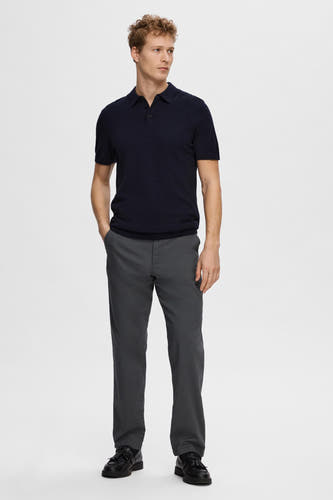 Blauwe polo met korte mouwen van SELECTED, gecombineerd met grijze pantalon en zwarte schoenen met franjes.