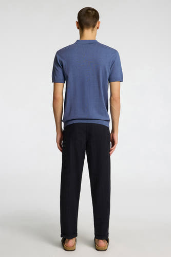 Polo bleu à manches courtes de SELECTED, porté par un homme, vue de dos, avec un pantalon noir et des sandales marron.