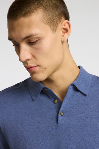 Polo en maille bleu à manches courtes de SELECTED avec boutons marron, porté par un homme.
