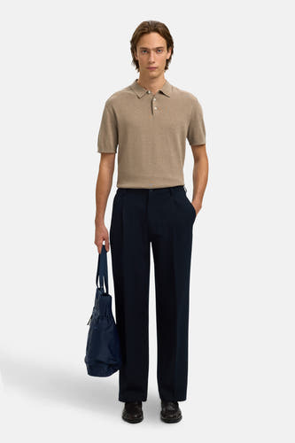 Polo à manches courtes marron de SELECTED, avec fermeture à boutons et portée avec un pantalon bleu foncé et un sac.