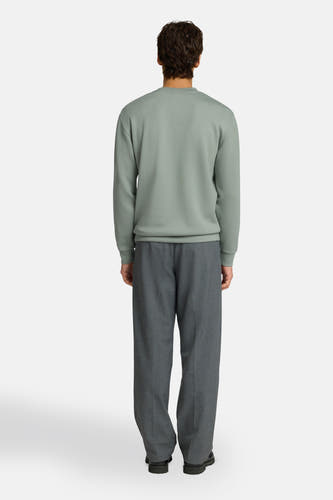 Pull vert à col rond de SELECTED, porté par un homme, vue de dos, associé à un pantalon gris.