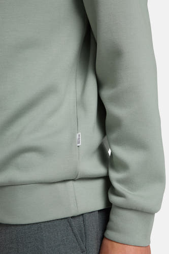 Pull vert de SELECTED avec des bords côtelés et une étiquette blanche sur la couture latérale.