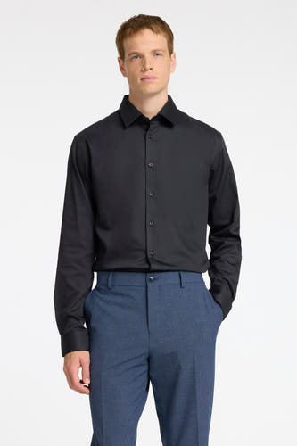 Chemise noire à manches longues de SELECTED, avec col boutonné et associée à un pantalon bleu.