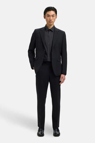 Chemise noire à manches longues de SELECTED, portée sous un costume noir.