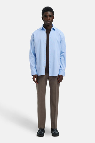 Bleu, chemise à longues manches de SELECTED portée avec un pull marron et un pantalon marron.