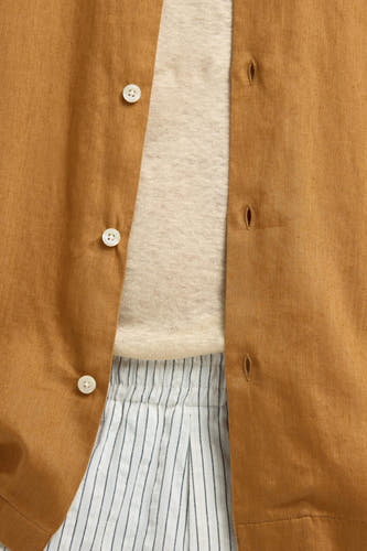 Chemise beige à manches courtes de SELECTED, portée ouverte sur un t-shirt rayé blanc.