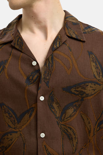 Chemise brune à manches courtes de SELECTED, avec un motif de feuilles et des boutons blancs.