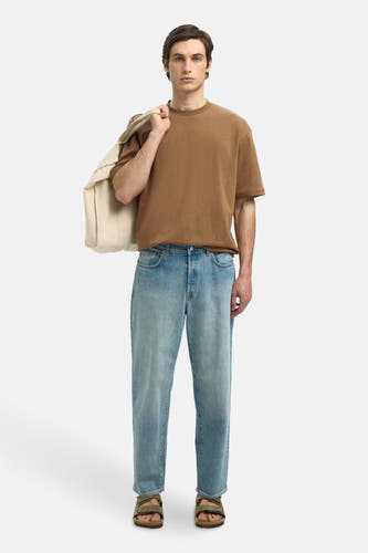 Bruin T-shirt met korte mouwen van SELECTED, gedragen met lichtblauwe jeans en sandalen, met een witte tas over de schouder.
