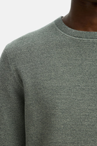 Groene gebreide trui.