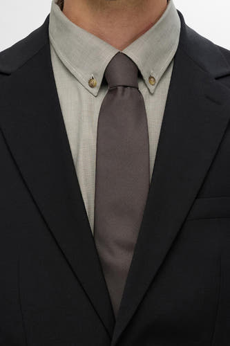 Duvet de SELECTED, avec une texture subtile et porté avec un chemisier gris clair et une veste noire.