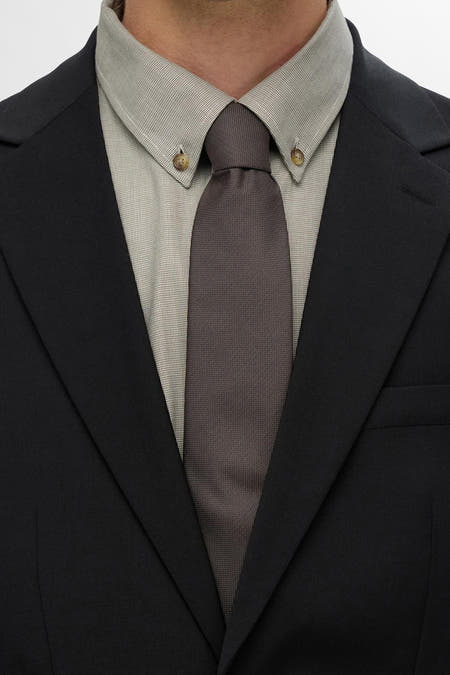 Duvet de SELECTED, avec une texture subtile et porté avec un chemisier gris clair et une veste noire.