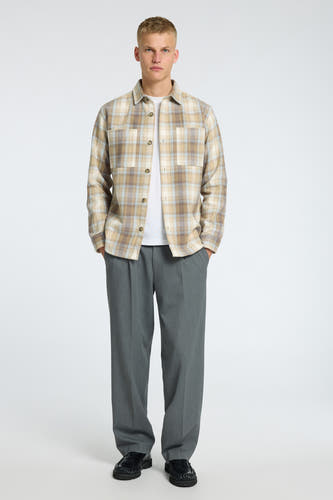 Chemise beige à longues manches de SELECTED, avec un motif à carreaux, portée sur un t-shirt blanc et un pantalon gris.