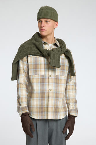 Chemise beige à longues manches de SELECTED, avec un motif à carreaux et une veste verte sur les épaules.