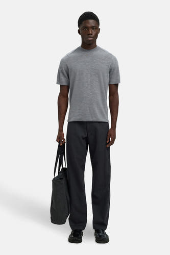 Sweat-shirt gris de SELECTED, avec des manches courtes, associé à un pantalon foncé et une sacoche noire.