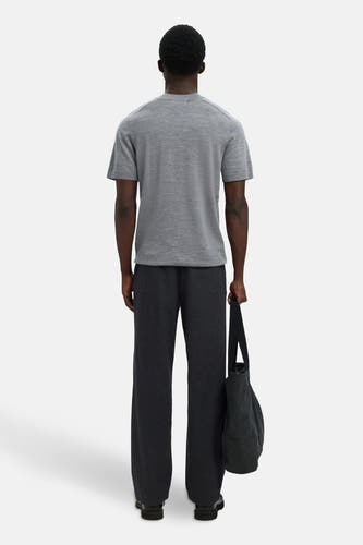 Sweat gris SELECTED, vu de de lrièrerière un pantalon pant et une sac noir.