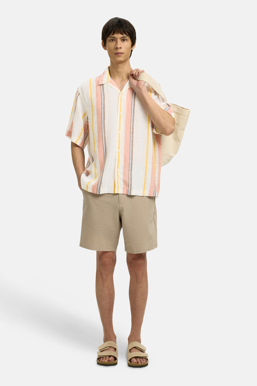 Chemise multicolore à manches courtes de SELECTED, motif rayé avec des couleurs pastel, portée avec un short kaki et des sandales.