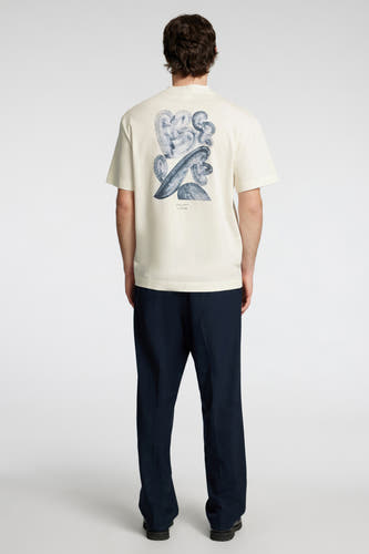 T-shirt écru à manches courtes de SELECTED, avec une impression abstraite bleue sur le dos, associé à un pantalon marine.