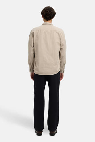 Chemise beige à longues manches de SELECTED, avec col boutonné et portée avec un pantalon noir et des chaussures marron.