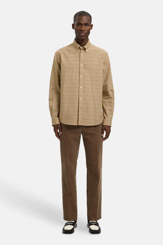 Chemise brune à manches longues de SELECTED, avec un motif rayé, portée avec un pantalon corduroy brun.