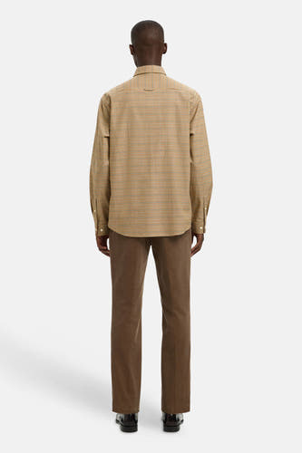 Chemise brune à manches longues de SELECTED, avec un motif à carreaux et portée avec un pantalon corduroy brun.